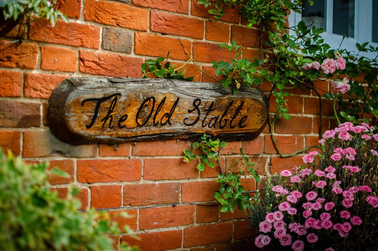 the old stable signage near pink flowers